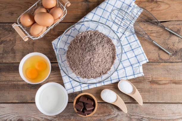 istock Ingredients for making cake chocolate on a wooden background. 672011460