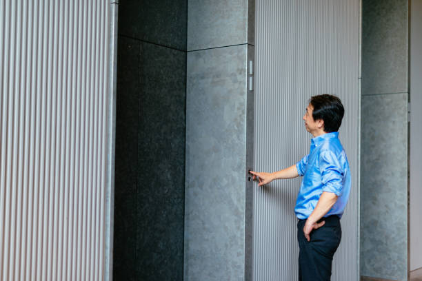 istock Japanese mature man standing in front of the elevator 672016198