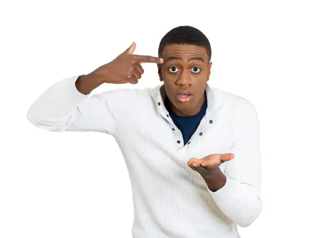 Closeup portrait rude difficult angry young student man gesturing with finger against temple are you crazy? Isolated white background. Negative human emotion facial expression feeling