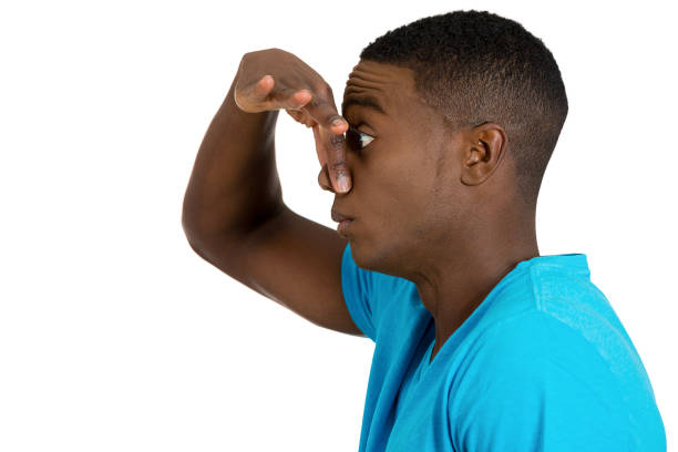 istock Closeup side view profile portrait young man disgust on face, pinches his nose, something stinks, very bad smell, situation, 672024268