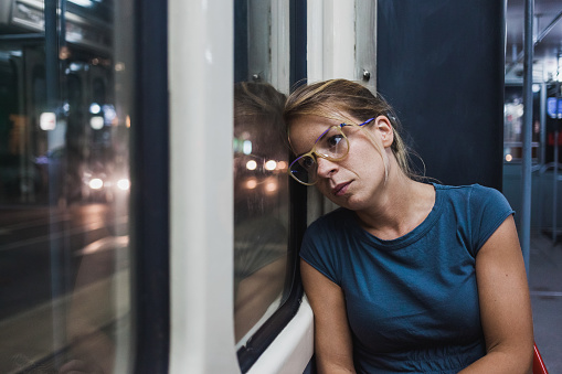 Young woman riding a public bus at night