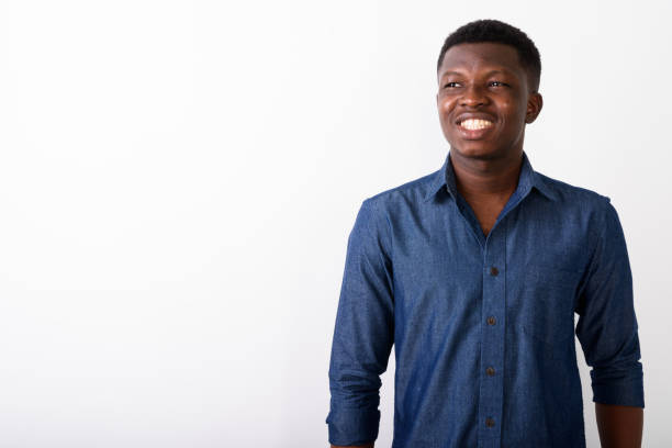 istock Studio shot of young happy black African man smiling and thinking while looking up against white background 672030770