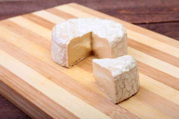 istock Cheese with white mold. Camembert or brie type on wood table. Healthy breakfast. 672033546