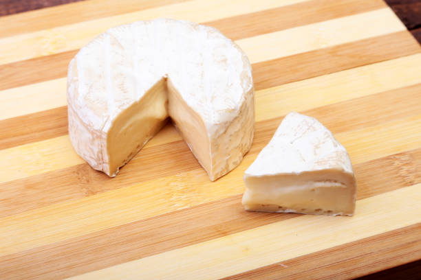 istock Cheese with white mold. Camembert or brie type on wood table. Healthy breakfast. 672033564