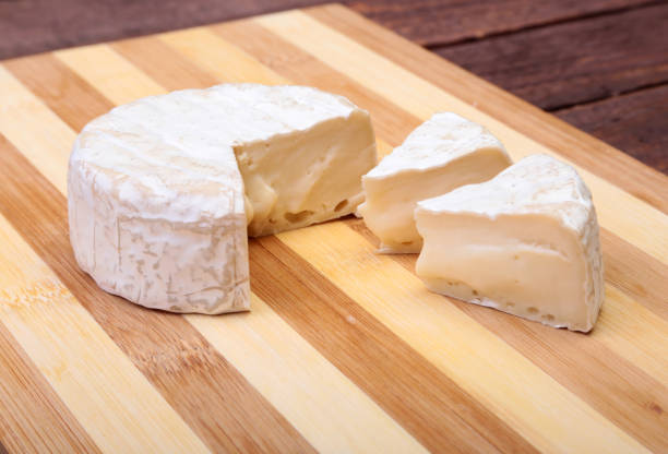 istock Cheese with white mold. Camembert or brie type on wood table. Healthy breakfast. 672033776
