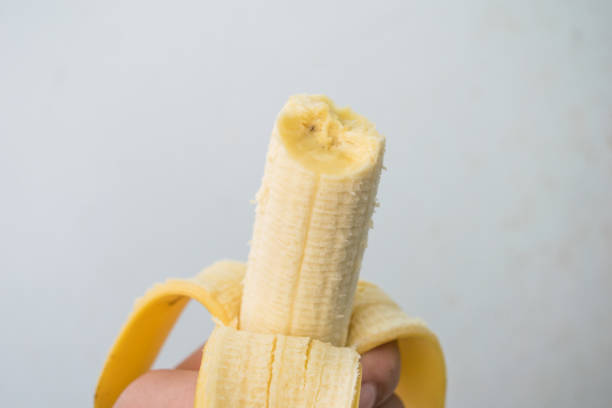 istock hand holding banana and eating 672039718