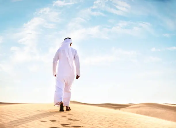 Photo of arabic man praying in the desert