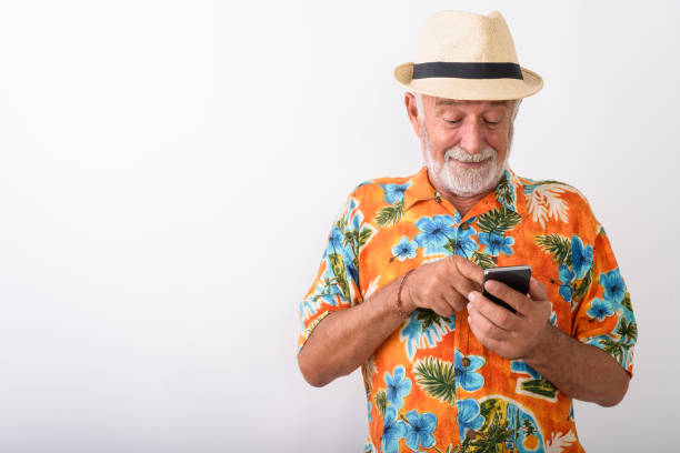 istock Senior Tourist Man Vlogging Using Mobile Phone While Wearing Hawaiian Shirt 672050550