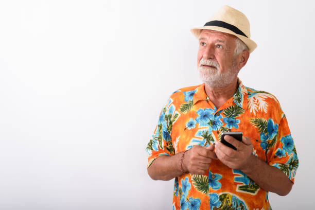 istock Senior Tourist Man Vlogging Using Mobile Phone While Wearing Hawaiian Shirt 672050562