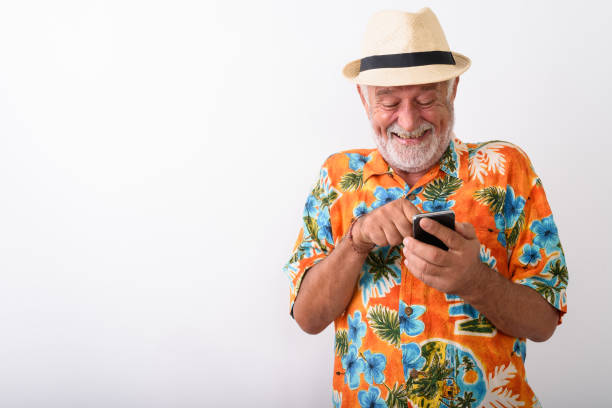 高級旅遊的人將穿著夏威夷襯衫時使用行動電話 - 老年人 圖片 個照片及圖片檔