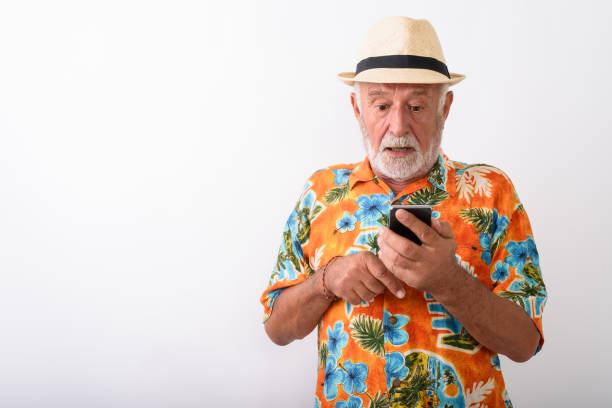 istock Senior Tourist Man Vlogging Using Mobile Phone While Wearing Hawaiian Shirt 672050622