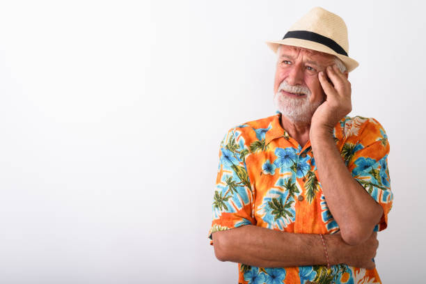 istock Studio shot of senior bearded tourist man thinking while looking stressed and wearing hat against white background 672050626