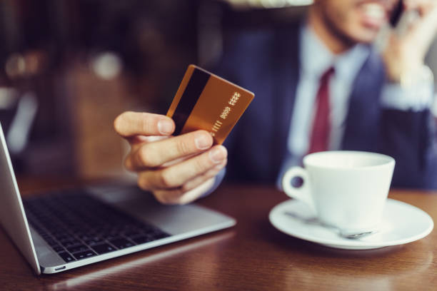 бизнесмен в кафе с помощью кредитной карты для интернет-магазинов - buying shopping computer cup стоковые фото и изображения
