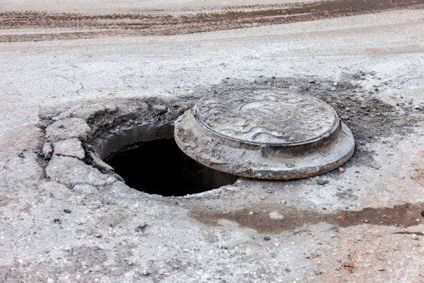 istock Open unsecured sewer manhole on the city street 672061318