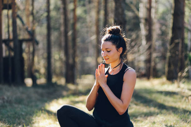istock Young woman doing yoga in nature 672064600