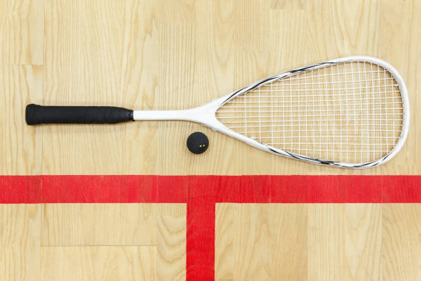 squash racket and ball top view white squash racket and ball on the wooden floor top view. Racquetball equipment on the court near red line racketball stock pictures, royalty-free photos & images