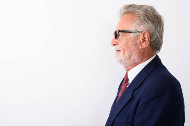 Profile view of happy senior bearded businessman smiling while wearing eyeglasses against white background Profile view of happy senior bearded businessman smiling while wearing eyeglasses against white background horizontal shot white hair photos stock pictures, royalty-free photos & images