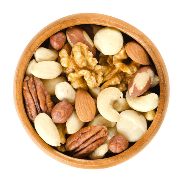 istock Raw mixed nuts in wooden bowl over white 672067936