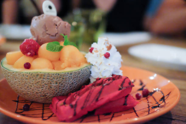 istock Ice cream with cantaloupe and waffle on orange plate 672070438