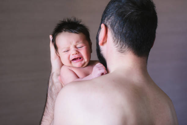 istock Baby boy crying on his father shoulder 672070916
