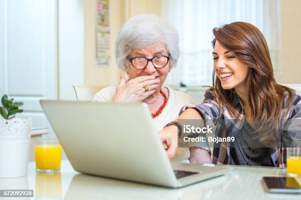 Enkelin Zeigt Auf Etwas Auf Laptopbildschirm Zu Ihrer Oma Zu Hause Stockfoto und mehr Bilder von Alter Erwachsener