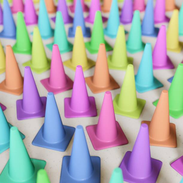 istock Tight Upright Group of Variously Colored Traffic Cones on a Concrete Floor 672093972