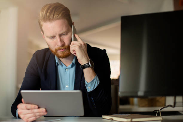 istock Businessman using tablet and takling on mobile phone 672096552