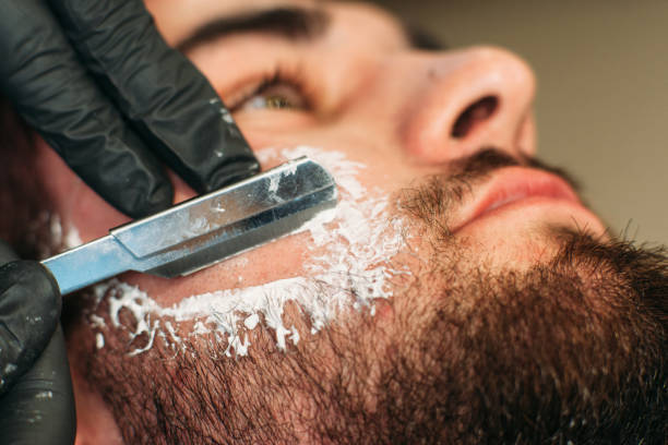 Shaving bearded man face closeup