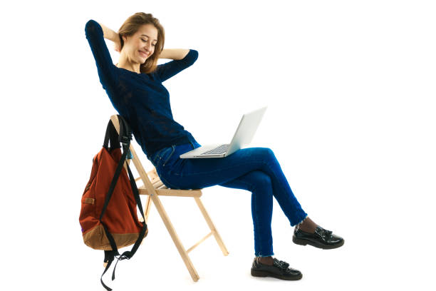 girl sitting on a chair with laptop stock photo