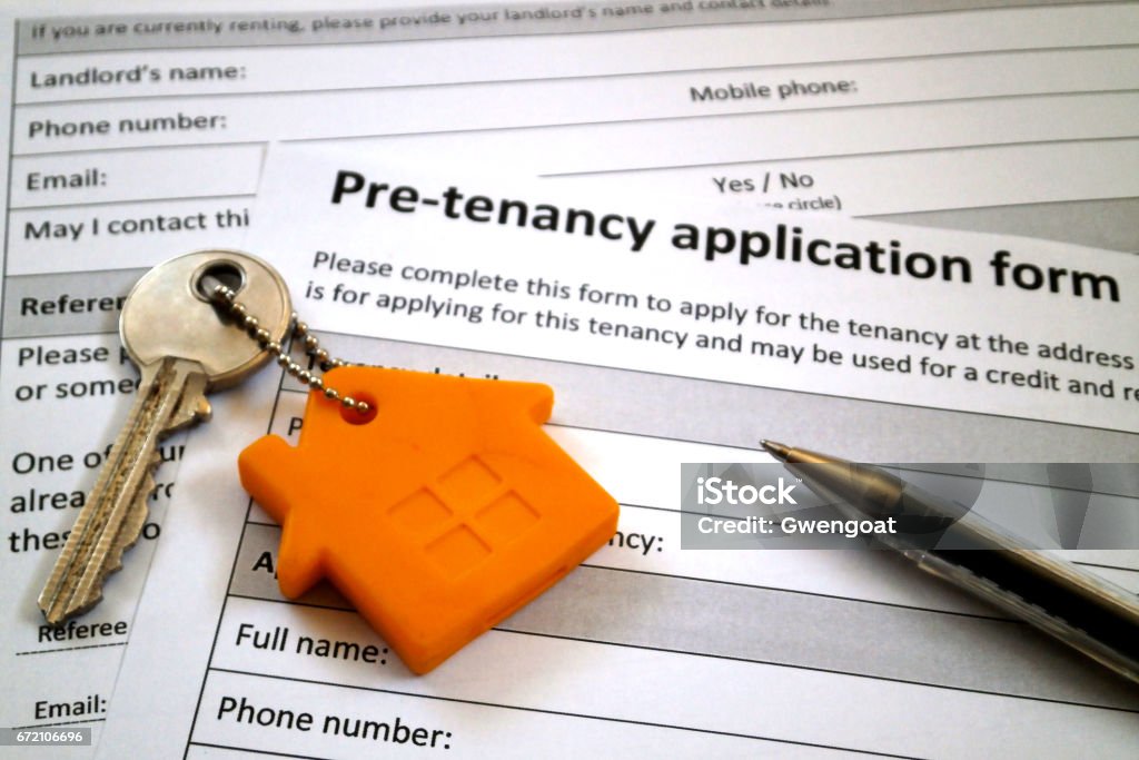 Pre-tenancy application form Pen and a apartment key on the top of a pre-tenancy application form. Application Form Stock Photo