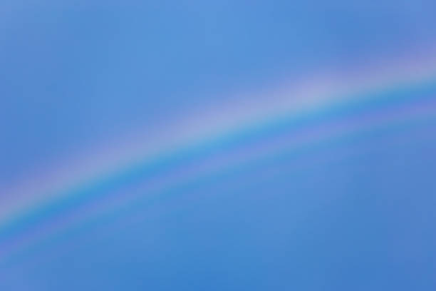 istock Blue sky with rainbow. Very bright rainbow with flashy colors and a dark blue sky 672109928