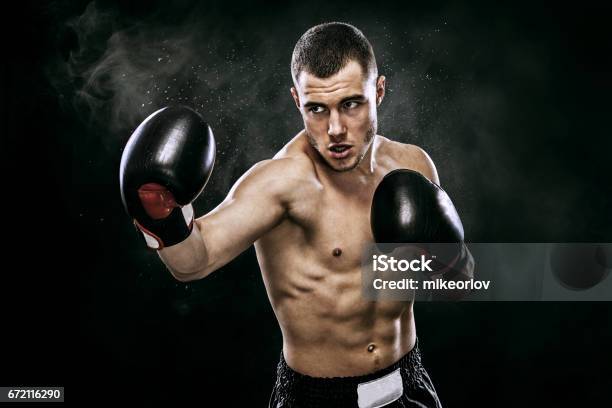 Sportsman Muay Thai Boxer Fighting In Gloves In Boxing Cage Isolated On Black Background With Smoke Copy Space Stock Photo - Download Image Now