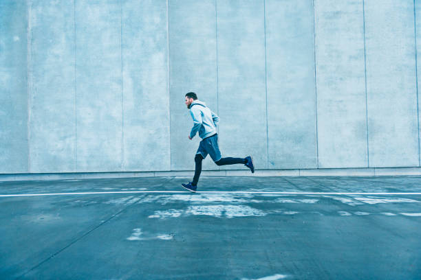 Fast runner makes his way past a big grey concrete wall