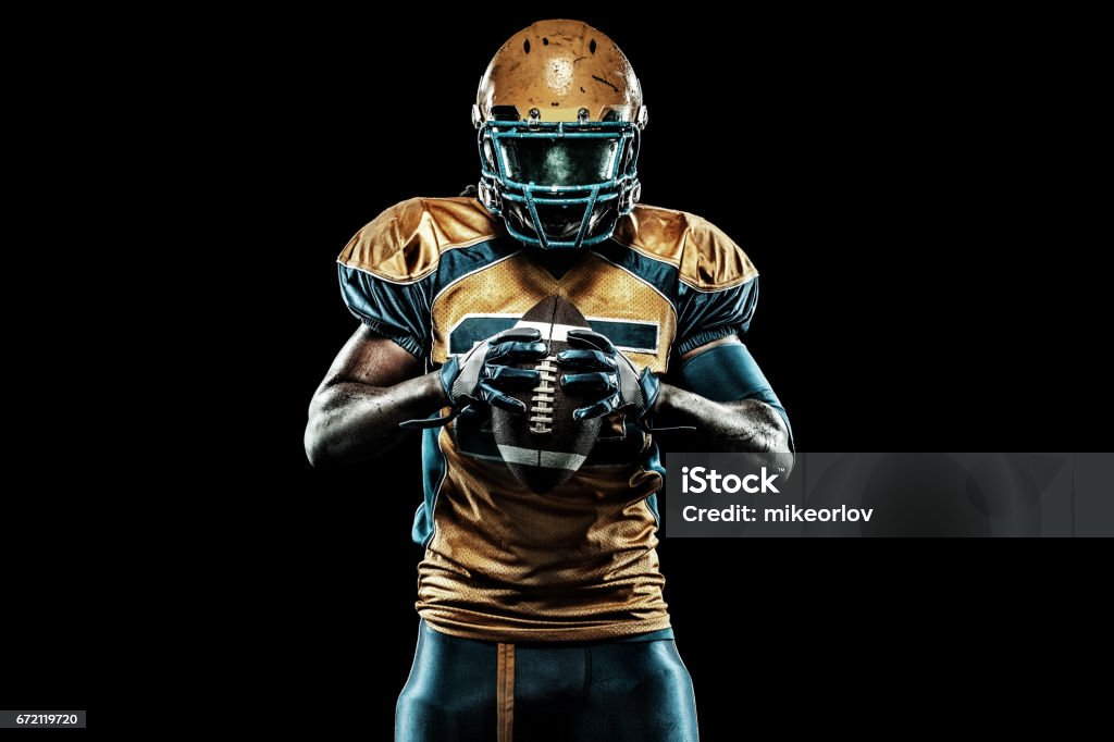 Jogador de futebol americano esportista isolada no fundo preto - Foto de stock de Escuro royalty-free