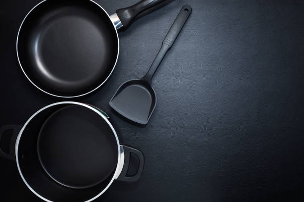 istock Top view frying pan and pot on black table. 672119744