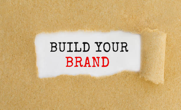istock Text Build Your Brand appearing behind ripped brown paper. 672119980