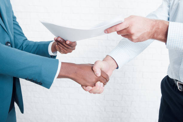 Shaking hands after signing business contract Handshake in office after making deal. Two owners of business signed contract about interracial cooperation. dealing cards stock pictures, royalty-free photos & images