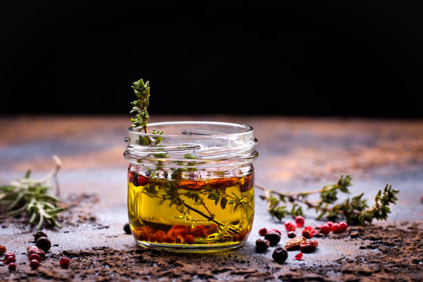 olive oil flavored with spices - pink peppercorn imagens e fotografias de stock