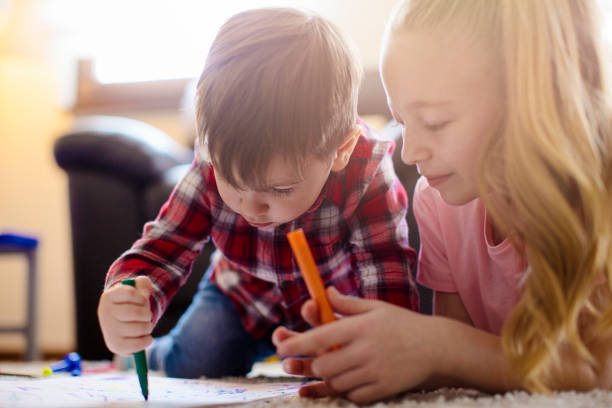 istock Little boy drawing with his sister 672130184