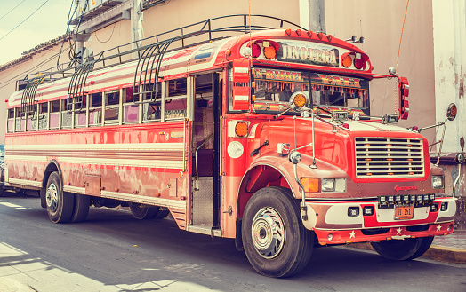 Granada: Colorful bus waiting for passengers on the street of historic town of Granada in Nicaragua.