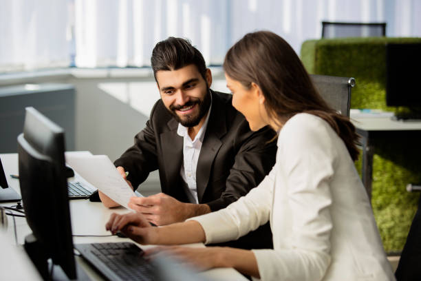 istock Man and woman in office working together near computer 672143038