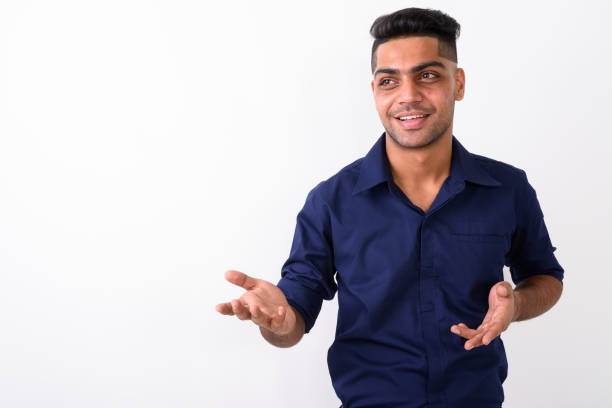 istock Studio shot of young happy Indian businessman smiling while explaining something against white background 672150070