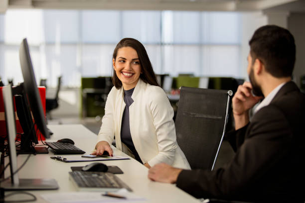 istock Man and woman in office sitting and smiling 672152302