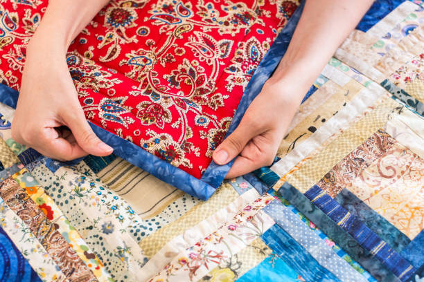 istock The caucasian female hand touching a color patchwork quilt with blue geometry pattern. Part of Colorful Scrappy blanket. Handmade 672152500