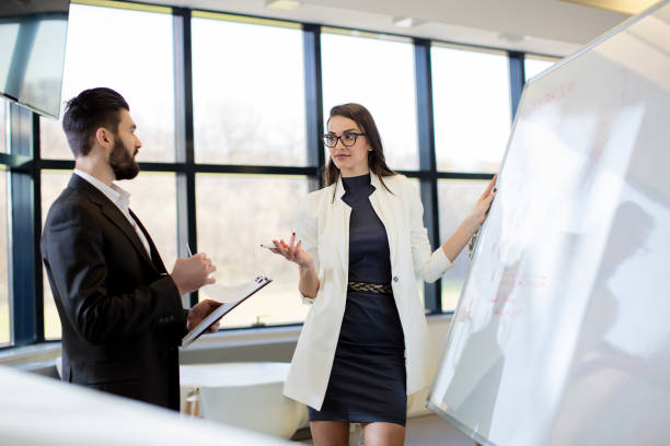 istock Two young business people discussing business strategy 672152754
