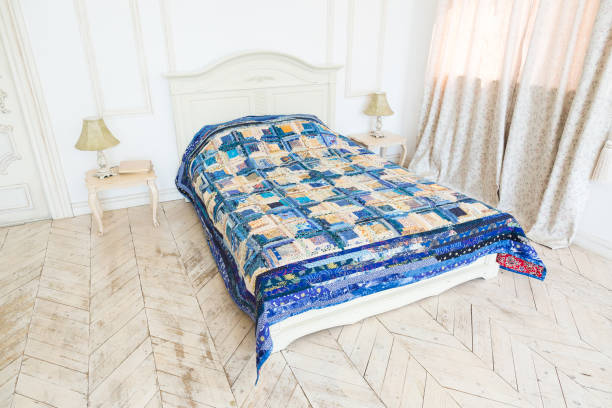 istock large bright double bed with a colored patchwork quilt in the white interior. scrappy blanket on the bed closeup 672153422