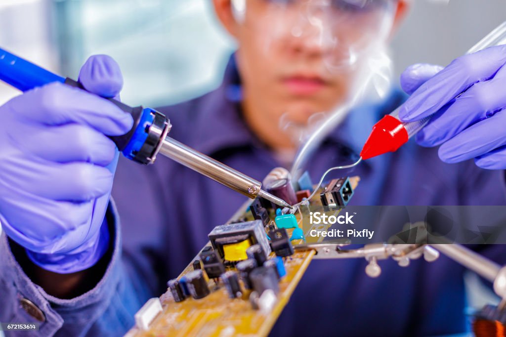 Ingénieur ou technicien réparation circuit imprimé avec le fer à souder - Photo de Fer à souder libre de droits