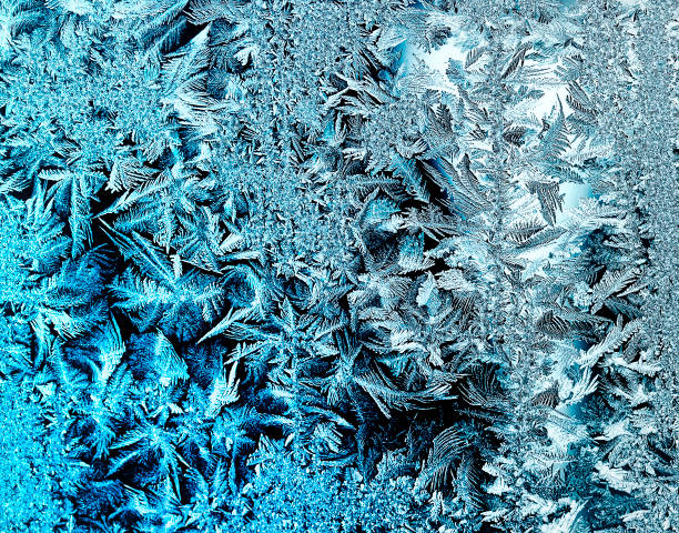 istock beautiful frosty pattern with swirls and feathers on cold glass 672157530