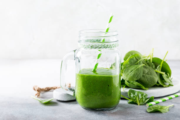istock Healthy green smoothie with spinach in glass jar 672161102