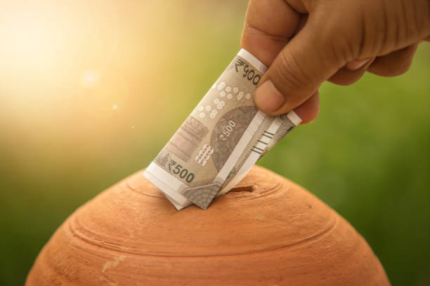 Saving money Hand putting money into piggy bank. New Indian currency of 500 rupee notes. 2000 photos stock pictures, royalty-free photos & images